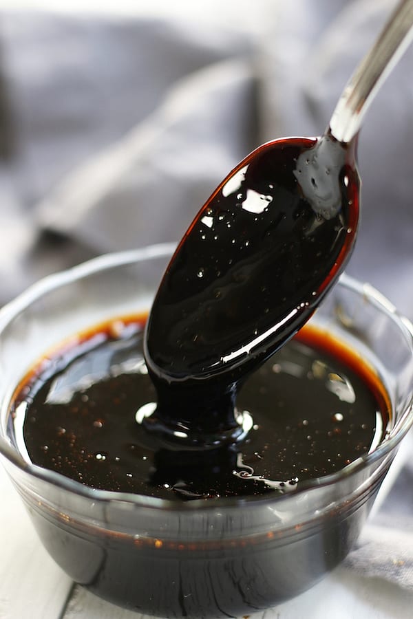 The start of Balsamic Reduction being drizzled from a spoon.