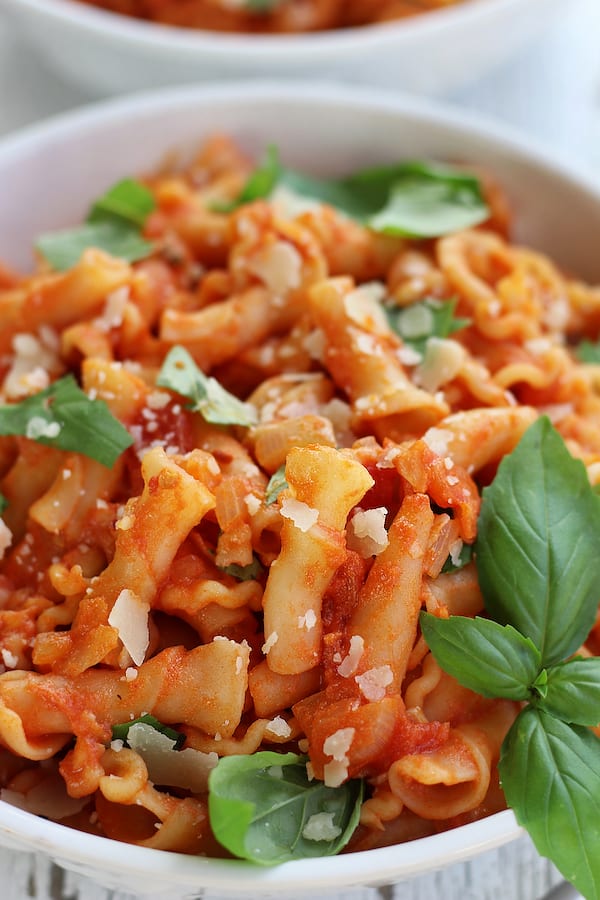 Up close photo of the Best Vodka Sauce Recipe on top of noodles with basil leaves.