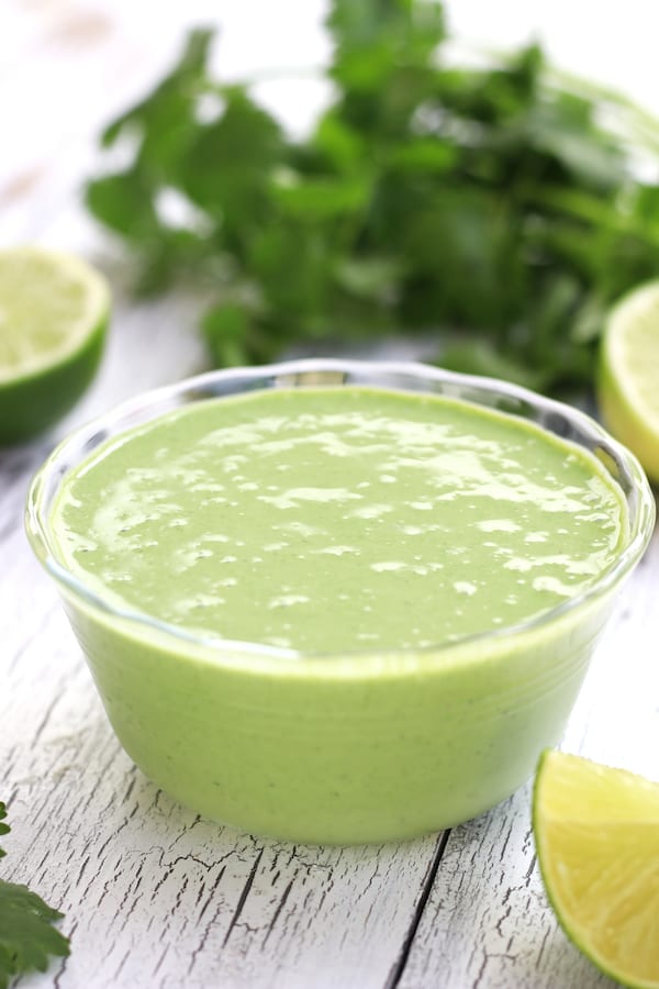 Cilantro Sauce in a clear bowl sitting on a white table.