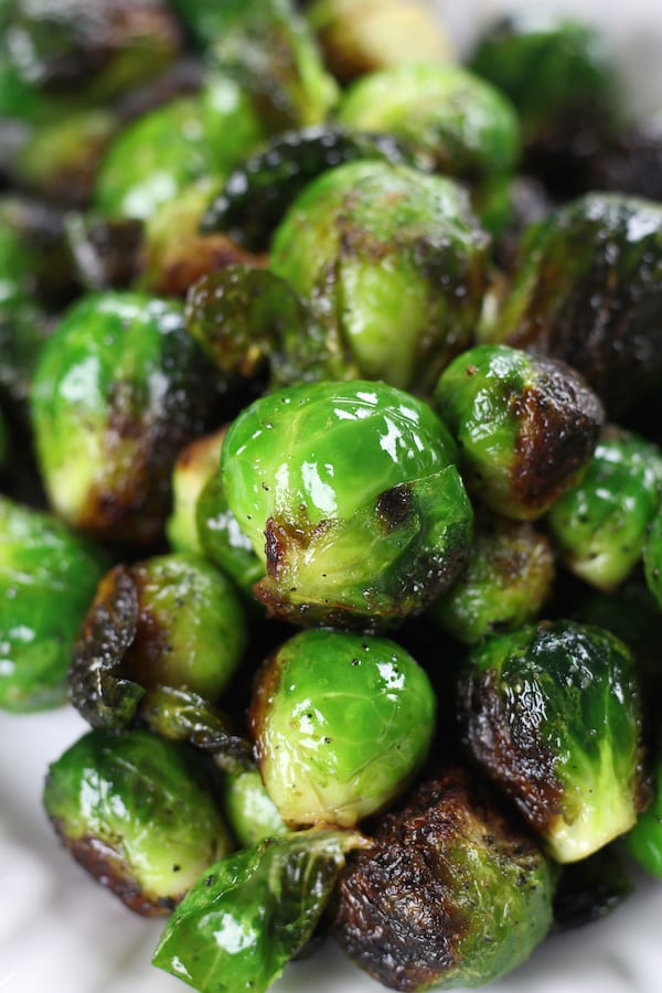 Brussel Sprouts on a white plate from Grilled Brussel Sprouts Recipe.