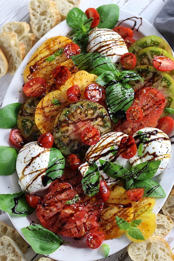 Overhead shot of an Italian Appetizer of tomatoes, Burrata, basil and balsamic glaze.