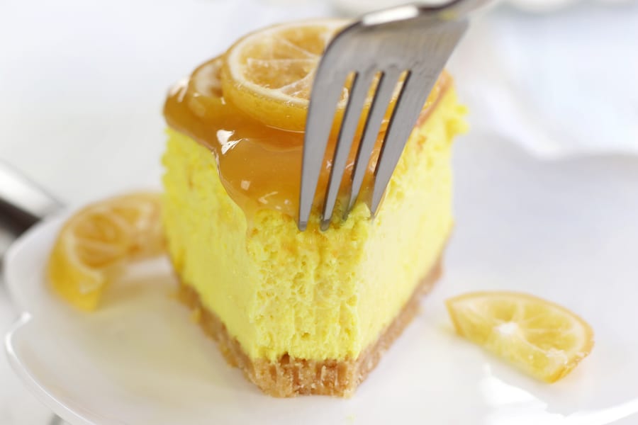 Fork cutting into slice of Lemon Curd Cheesecake.