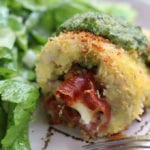 Pesto Chicken Rollatini on a plate with salad.