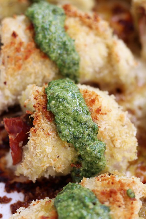 A row of Stuffed Chicken rolls covered in Panko with pesto.