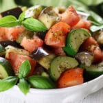 Vegan Ratatouille in a white bowl on a white wooden table.