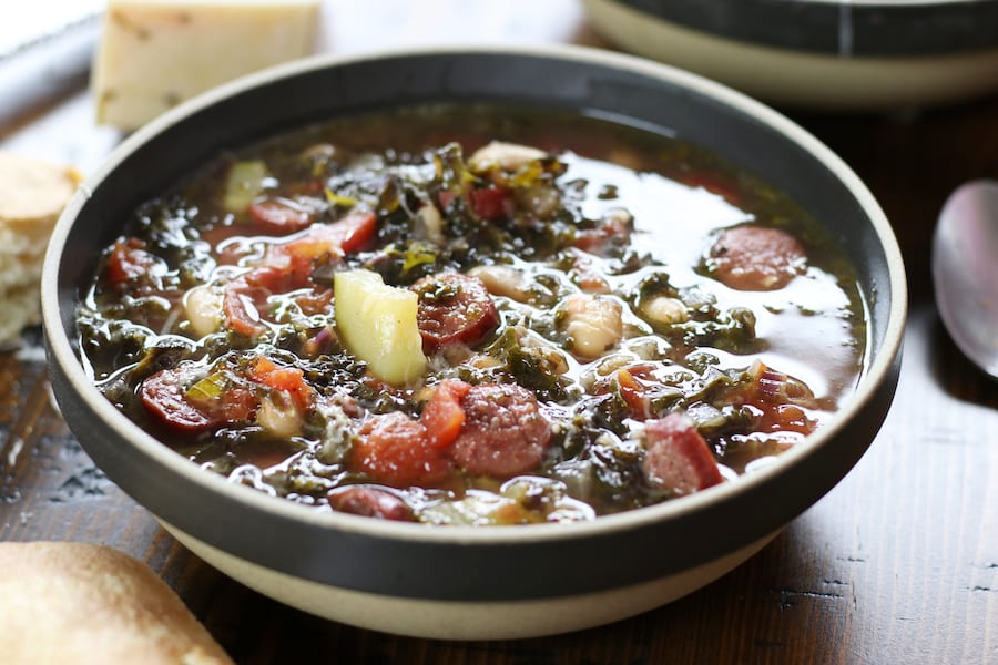 White Bean Soup in a bowl on a brown table.