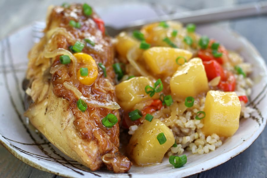 A plateful of Healthy Sweet and Sour Chicken with a chicken breast and brown rice.