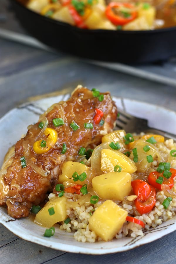 Homemade Sweet & Sour Chicken served on a plate with a skillet full in background.