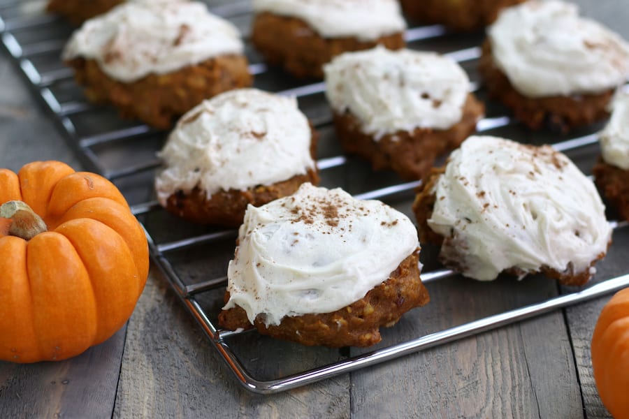 Iced Pumpkin Cake Cookies lined up on a cooling rack.