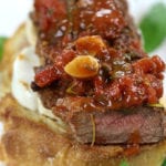 Up close Steak Pizzaiola Recipe on top of garlic toast.