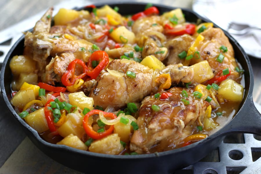 Sweet and Sour Chicken Recipe with whole chicken pieces in a cast iron skillet.