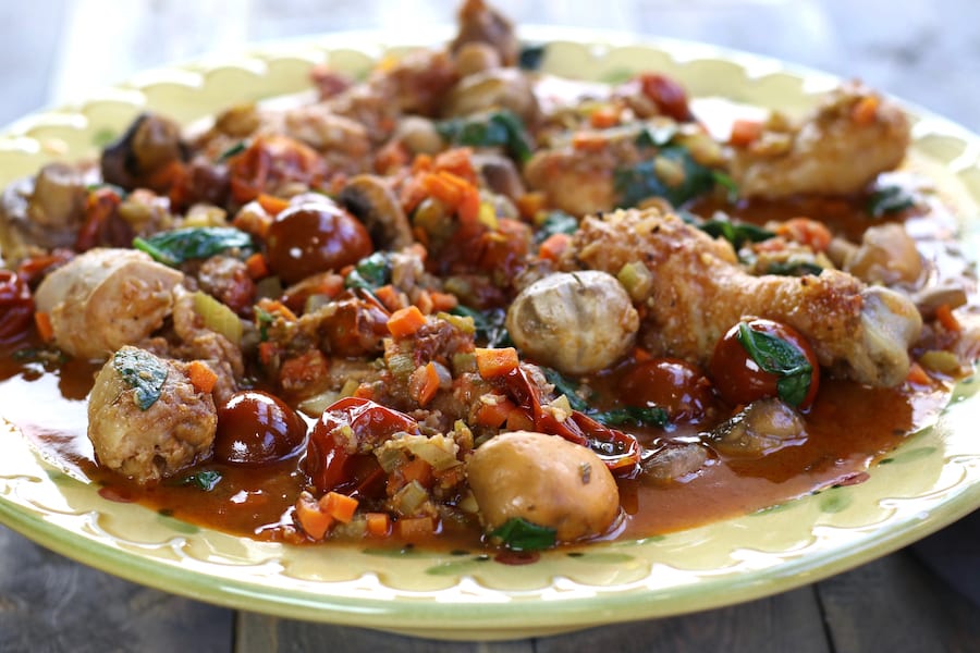 Family style serving bowl of Tuscan Chicken Stew sitting on a wooden table.