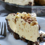 A slice of Mom's Frozen Peanut Butter Pie on a white plate.