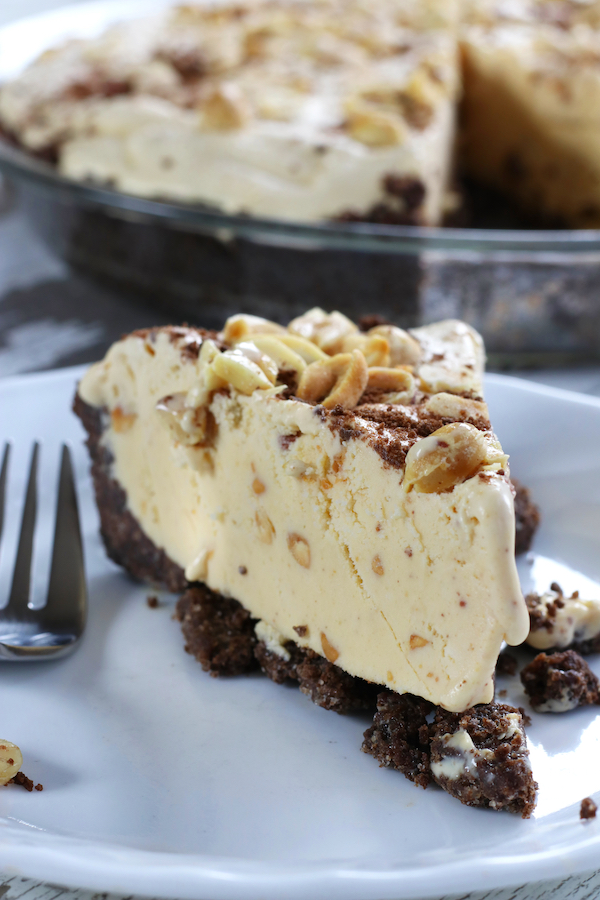 One piece of Peanut Butter Pie on a plate with the whole pie behind it.