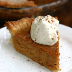A slice of Homemade Pumpkin Pie with whipped cream.