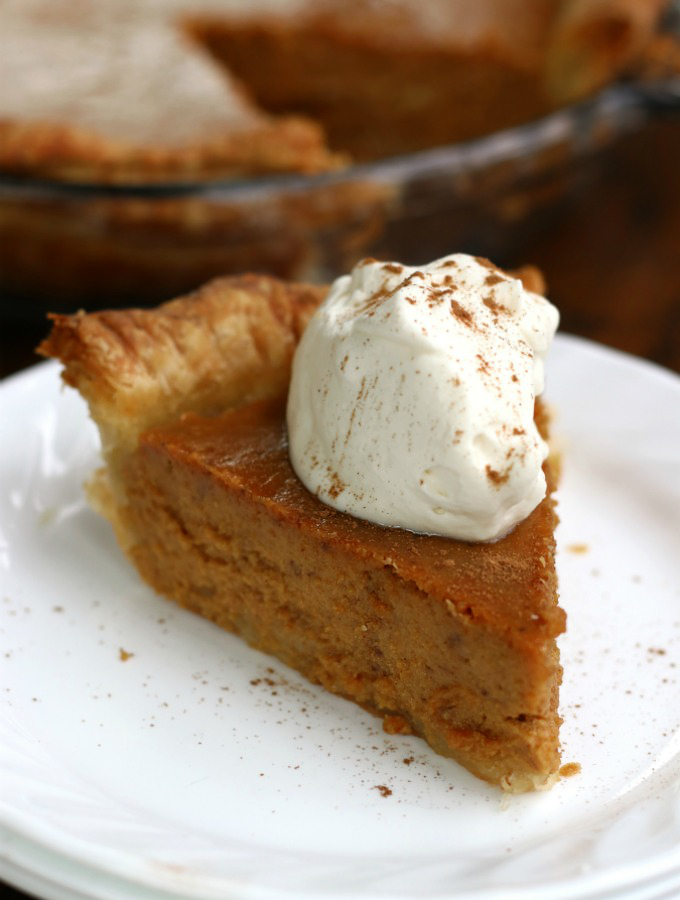 A slice of Homemade Pumpkin Pie with whipped cream.