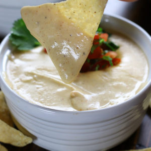 Nacho Cheese covering a hand held chip.