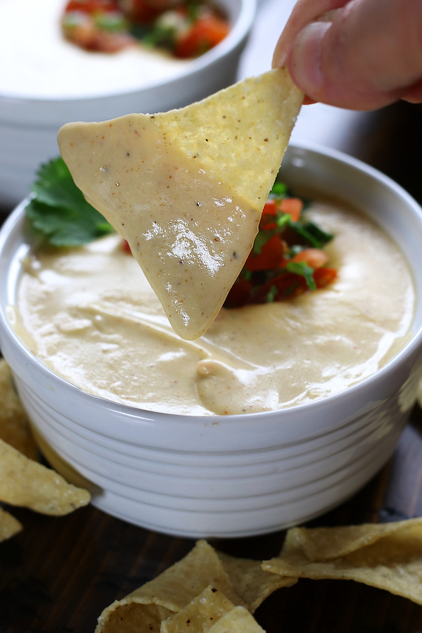 Nacho Cheese covering a hand held chip.