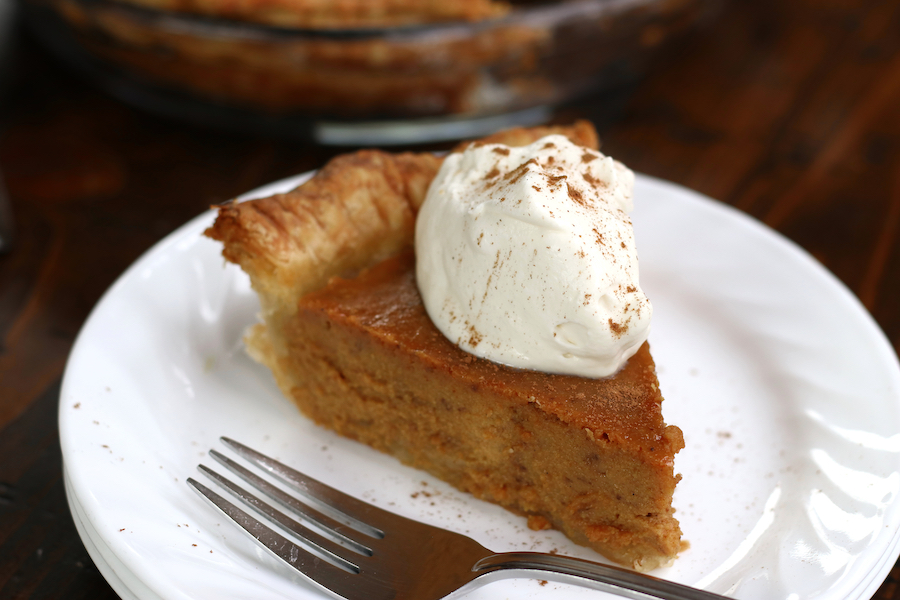 Serving of a Pumpkin Pie Recipe on a white plate with a fork.