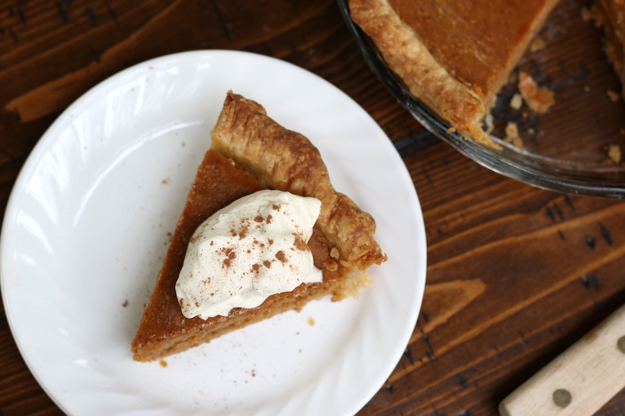 Overhead photo of a pumpkin pie with a slice of pie.