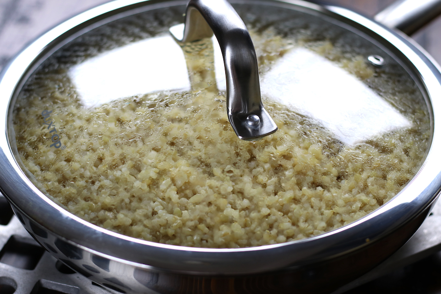 Photo of How To Cook Brown Rice in a stainless steel frying pan with a glass lid.