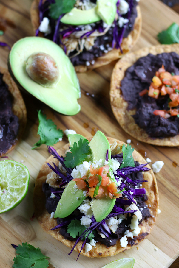 Mexican Tostadas with a cut avocado and half a lime.