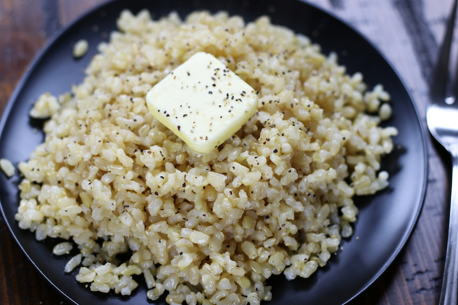 Perfect Brown Rice on black plate with a fork.