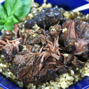 Poposo in a blue bowl with fresh basil garnish.