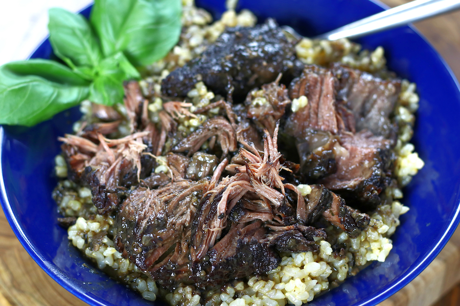 Poposo in a blue bowl with fresh basil garnish.