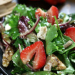 A serving of Strawberry Walnut Salad tossed in a balsamic vinaigrette.