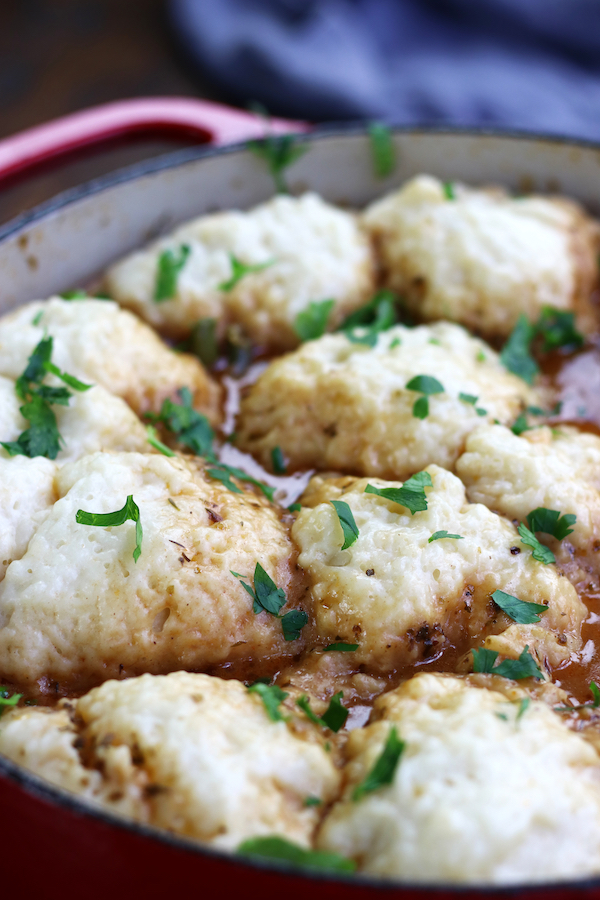 A red pot full of Beef Stew with Dumplings.