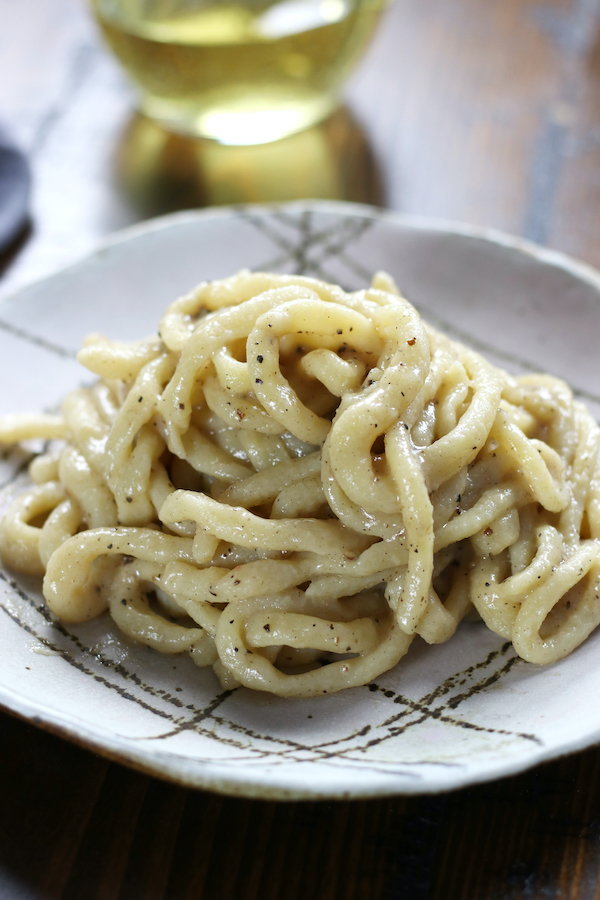 Cacio e Pepe sauce surround homemade Tuscan noodles.