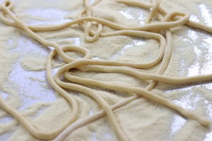 Rolled Pici Noodles on a Floured Cookie Sheet.