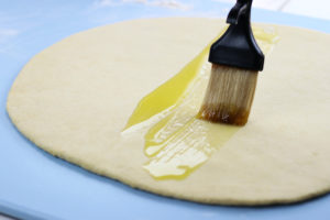 Spreading of Olive Oil with pastry brush on Rolled Pici Dough.