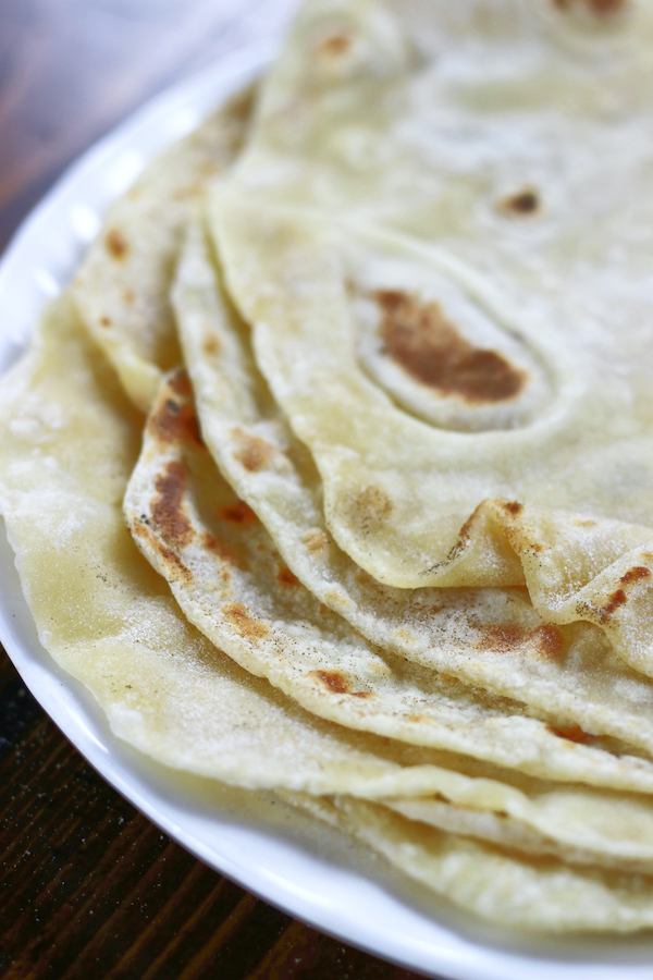 Fresh made tortillas on a white plate from Flour Tortillas Recipe.