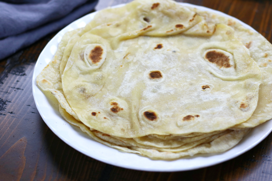 Vegan Flour Tortillas sitting on a wooden table.