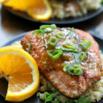 Pan Seared Salmon with Orange Ginger Glaze sitting on a black plate.