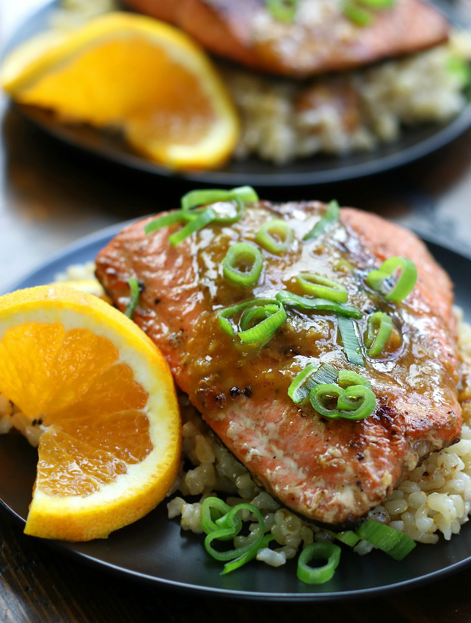 Pan Seared Salmon with Orange Ginger Glaze sitting on a black plate.