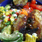 A Chicken Bowl with cut avocado, fresh cut corn, tomatoes and pineapple salsa.