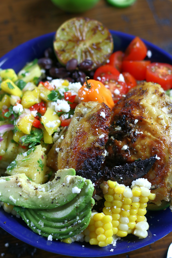 A Chicken Bowl with cut avocado, fresh cut corn, tomatoes and pineapple salsa.