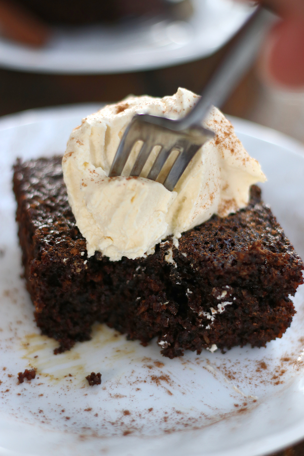 A fork taking a bite out of a slice of Old Fashioned Molasses Cake.