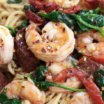 Up close photo of Prawn Spaghetti with chorizo, spinach and roasted red bell pepper strips.