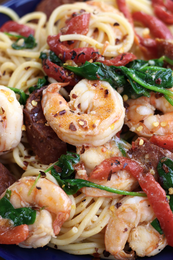 Up close photo of Prawn Spaghetti with chorizo, spinach and roasted red bell pepper strips.