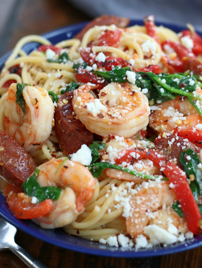 Prawn and Chorizo Pasta in a blue bowl garnished with crumbled cheese.