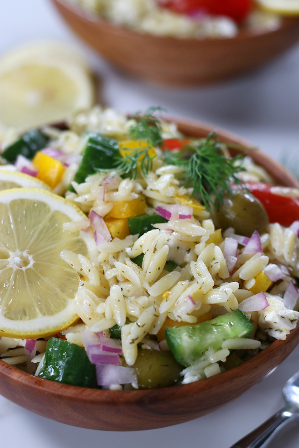 Up close photo of Risoni Salad with lemon slices and fresh dill sprigs.