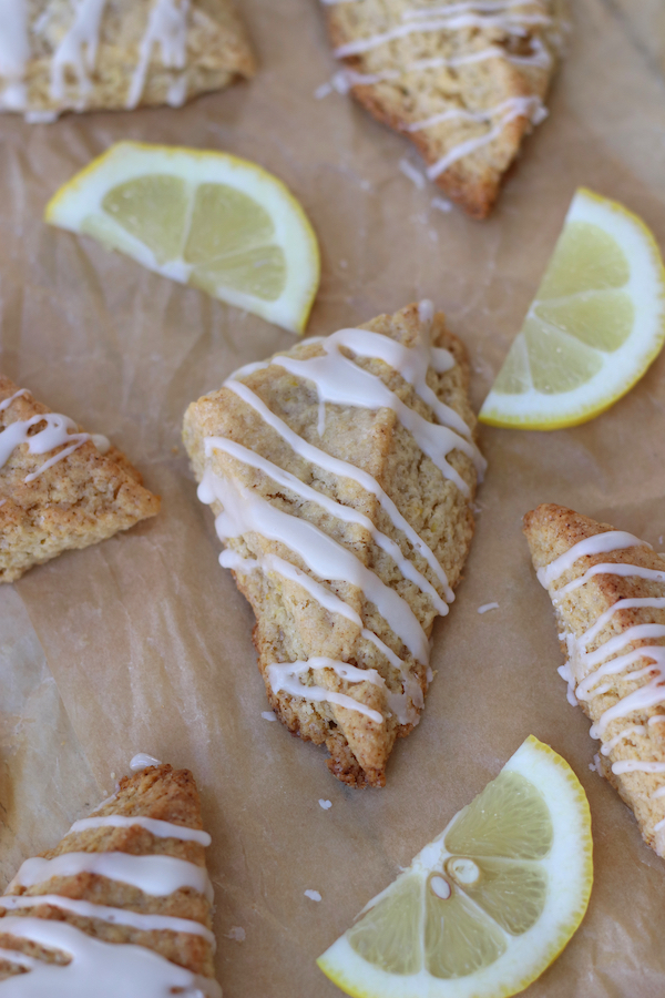 Overhead photo of Lemon Cream Biscuits on parchment with lemon slices.