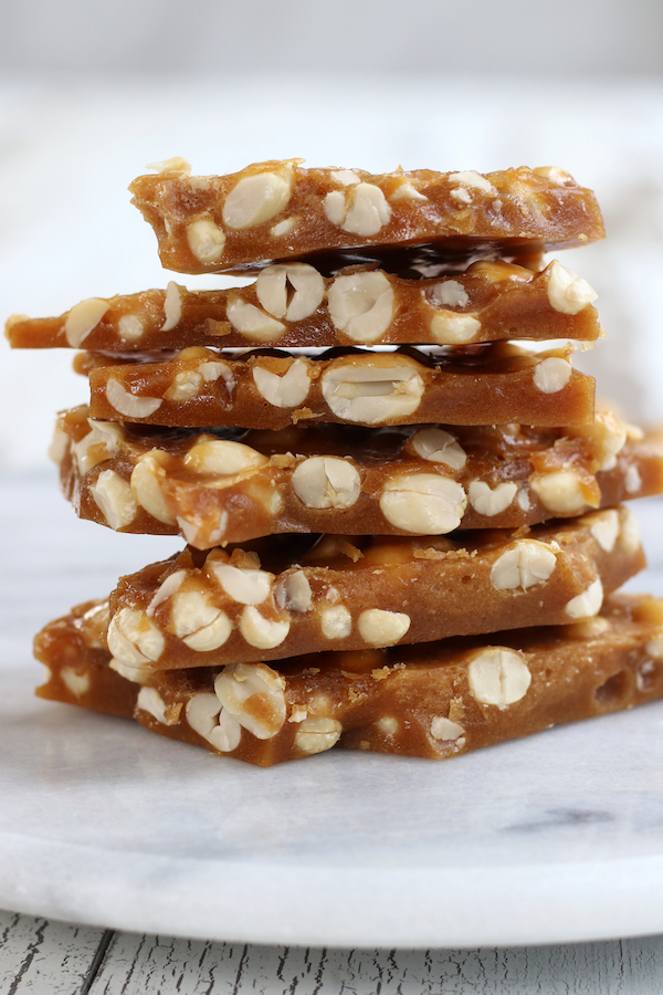 Five Peanut Brittle pieces stacked on top of a white lazy Susan.