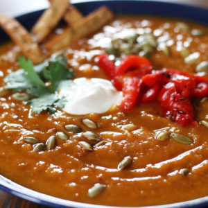 Sweet Potato Chorizo Soup garnished with roasted red peppers, cilantro and fried corn tortilla strips.