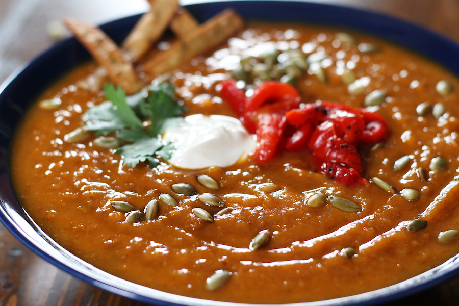 Sweet Potato Chorizo Soup garnished with roasted red peppers, cilantro and fried corn tortilla strips.