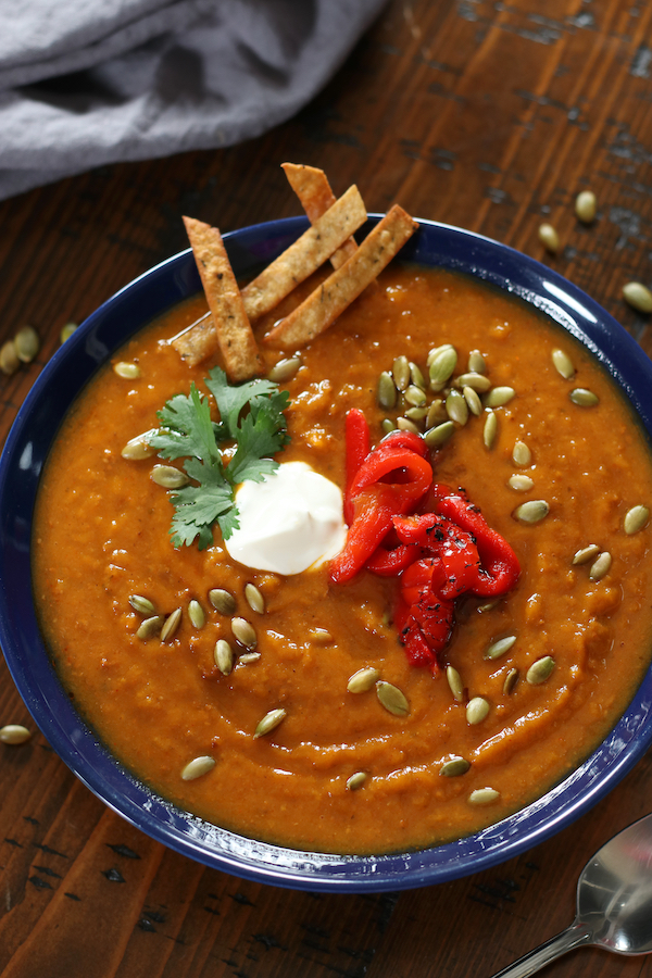 Overhead photo of Sweet Potato Soup Recipe in a blue bowl sitting on a brown table.